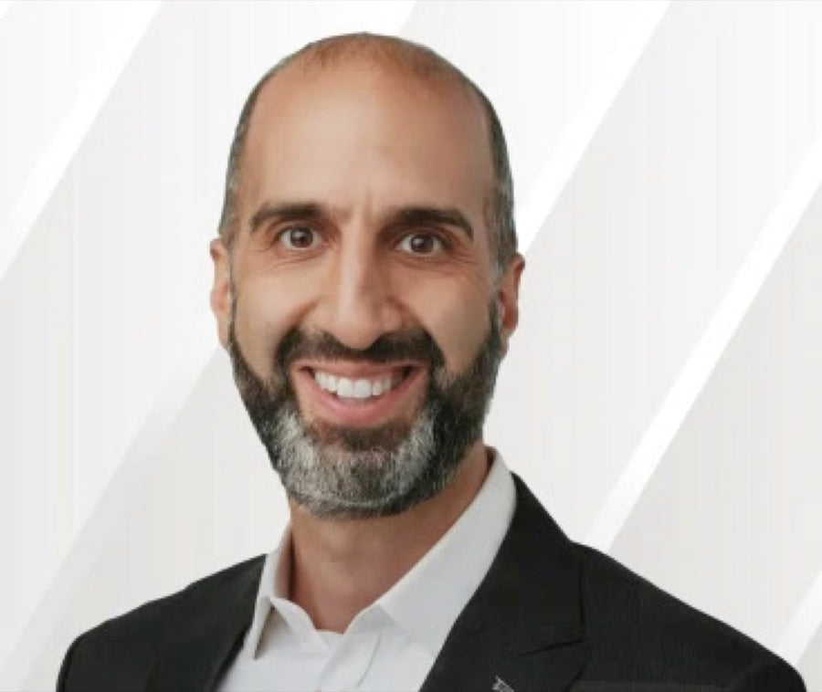 Dr. Jay Khorsandi smiling in a dark suit and white shirt