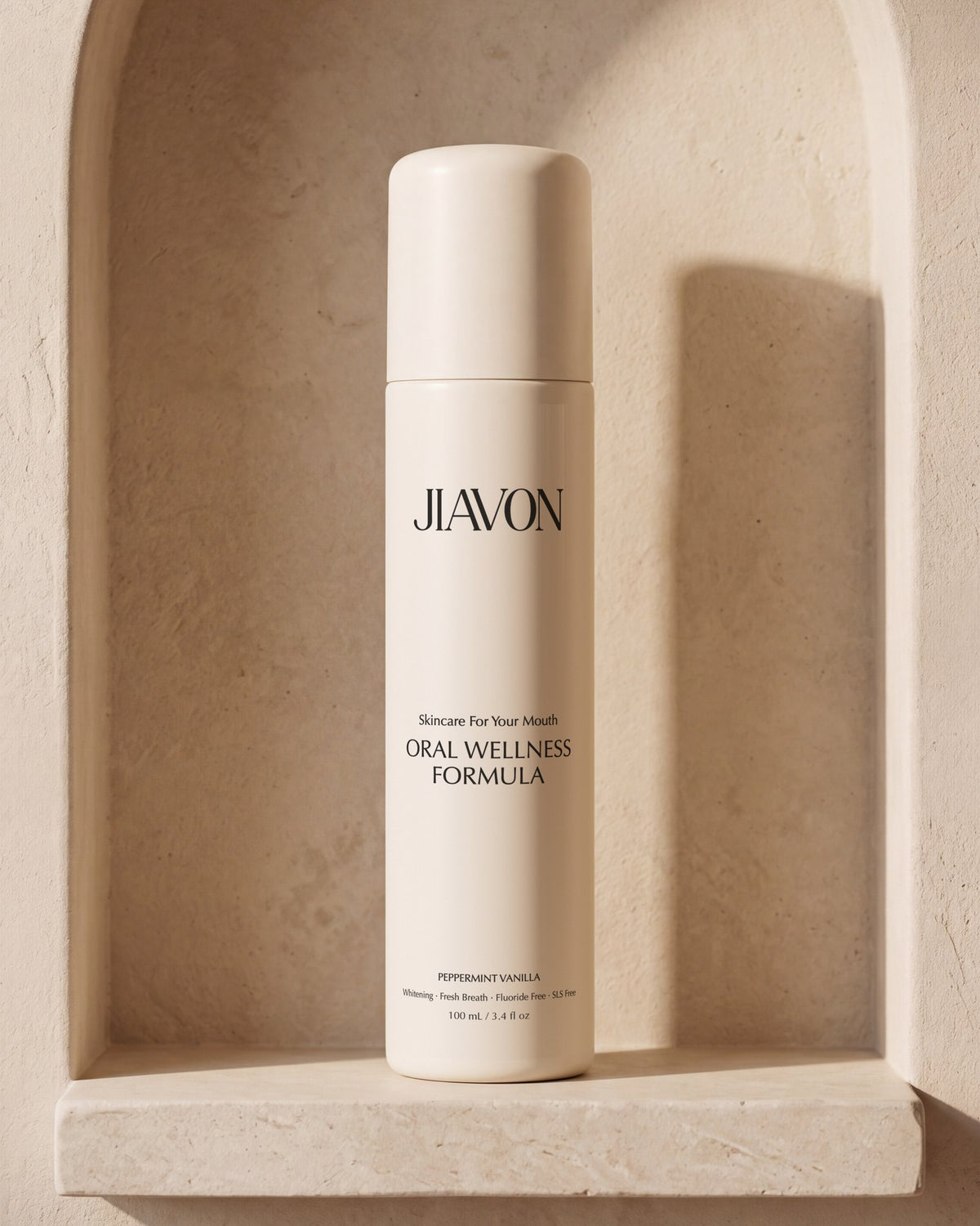 The JIAVON Oral Wellness Formula bottle in an arched limestone niche in late afternoon light